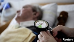 A nurse checks the pressure in the trachea of an 83 year-old man in a permanent vegetative state, at the Franziska Schervier intensive care nursing home in Frankfurt April 12, 2011. The patient has been in this condition since suffering a stroke. REUTER