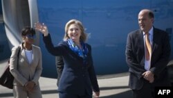 Ngoại trưởng Clinton (giữa) vẫy chào các nhà báo tại sân bay ở Haiti