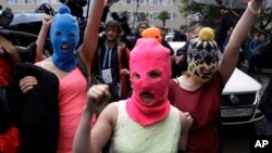 Pussy Riot üyelerinden Nadezhda Tolokonnikova (mavi kar maskeli) ve Maria Alekhina (pembe kar maskeli) gözaltından sonra serbest bırakıldı. 