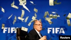 Diễn viên hài nổi tiếng người Anh Lee Nelson ném tiền vào cựu Chủ tịch FIFA Sepp Blatter khi ông đến tham dự cuộc họp báo sau Hội nghị bất thường Ban chấp hành FIFA tại trụ sở FIFA ở Zurich, Thụy Sĩ, ngày 20/7/2015.