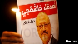 Một người biểu tình cầm biểu ngữ với hình của nhà báo Jamal Khashoggi bên ngoài lãnh sự quán Ả-rập Saudi ở Istanbul, ngày 25 tháng 10, 2018.