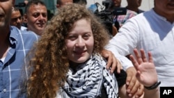 Ahed Tamimi vẫy tay chào mọi người khi tới thăm mộ cố lãnh đạo Palestine Yasser Arafat ở thành phố Ramallah ở Bờ Tây hôm 29/7. Biểu tượng đấu tranh của Palestine, Ahed Tamimi, và mẹ cô trở về nhà ở một ngôi làng ở Bờ Tây trong sự chào đón của người dân làng đối với một anh hùng.