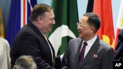 Ngoại trưởng Mỹ Mike Pompeo (trái) bắt tay chào Ngoại trưởng Triều Tiên Ri Yong Ho khi họ chuẩn bị chụp hình tập thể tại Diễn đàn Khu vực ASEAN lần thứ 25 ở Singapore, ngày 4 tháng 8, 2018. 