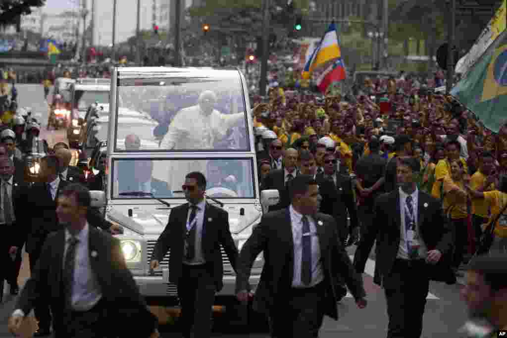 Giáo hoàng Phanxicô vẫy chào tín hữu Công giáo khi xe chở Ngài đi vào trung tâm thành phố Rio de Janeiro, 22 tháng 7, 2013.