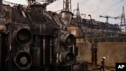 A worker walks in front of a transformer which was destroyed after a recent Russian missile attack at DTEK's power plant in Ukraine, Nov. 28, 2024.