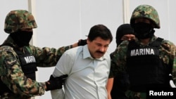 Joaquin Guzman (an sivil) nan mitan sòlda ki arete li nan vil Mexico (Foto: 22 fevriye 2014).