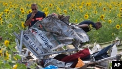 Nhân viên điều tra Hà Lan xem xét các mảnh vỡ của chiếc máy bay Malaysia Airlines tại làng Rassipne, vùng Donetsk, miền đông Ukraine.