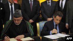 Tổng thống Pháp Nicolas Sarkozy (phải) và Tổng thống Afghanistan Hamid Karzai ký 1 hiệp ước hữu nghị và hợp tác tại Điện Elysee ở Paris, 27/1/2012