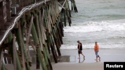 Khách du lịch đi bộ trên bãi biển Surfside, bang South Carolina trước khi bão tới, ngày 3/7/2014.