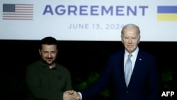 Ukrainian President Volodymyr Zelensky (L) and US President Joe Biden sign a bilateral security agreement during a press conference at the Masseria San Domenico on the sidelines of the G7 Summit hosted by Italy in Apulia region, on June 13, 2024 in Savell