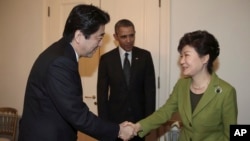 Tổng thống Nam Triều Tiên Park Geun-hye bắt tay Thủ tướng Nhật Bản Shinzo Abe. Tổng thống Obama đã đưa hai nhà lãnh đạo Nhật Bản và Nam Triều Tiên ngồi lại với nhau tại cuộc họp ở La Haye, ngày 25/3/2014.