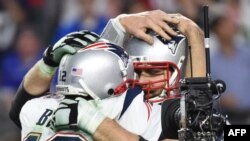 Thủ quân Tom Brady (trái) của đội New England Patriots và đồng đội ăn mừng chiến thắng.