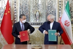 İran Dışişleri Bakanı Cevad Zarif Çinli mevkidaşı Wang Yi ile ikili anlaşmaların imzalandığı törende, 27 Mart 2021.