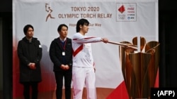 Một vận động viên thực hành thắp đuốc Olympic cho Thế vận hội Tokyo 2020 (15/2/2020). (Ảnh CHARLY TRIBALLEAU / AFP)