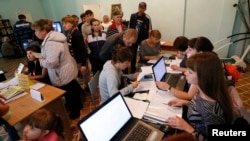 People, who have fled the fighting in the eastern regions of Ukraine, queue for job vacancies at an employment fair at the dormitories where they have taken refuge in Krasnoyarsk Russia, Sept. 2, 2014. 