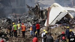 Rescue workers gather at the site of a plane crash in Lagos, Nigeria, June 4, 2012.