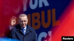 Turkey's President Tayyip Erdogan greets his supporters during a rally ahead of the local elections in Istanbul