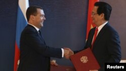 Thủ tướng Nga ông Dmitry Medvedev bắt tay với người đồng cấp bên phía Việt Nam là ông Nguyễn Tấn Dũng trong một buổi kí kết hợp tác tại Burbabai, Kazakhstan, ngày 29 tháng 05 năm 2015, sau khi Việt Nam kí thoả thuận hợp tác với khối EEU.