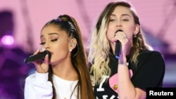 Ariana Grande (trái) và Miley Cyrus trên sân khấu đêm hòa nhạc 'Manchester One Love' gây quỹ từ thiện cho nạn nhân vụ đánh bom khủng bố ở Manchester, Anh, hồi tháng 5 vừa qua.