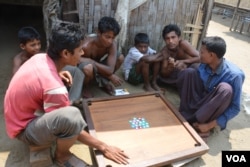 Những người đàn ông và trẻ em di trú Rohingya chơi trò Carrom ở trại Baw Du Pha 1 bên ngoài Sittwe.