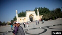 Người Hồi giáo Uighur đi bộ bên ngoài nhà thờ Hồi giáo ở Kashgar, Tân Cương.