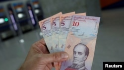 Nouvo lajan venezueyen an Bolivar Soberano (Bolivar Souvren) : biyè 5 ak 10 Bolivar, ki te fèk sòti nan kesye otomatik (ATM) nan yon bank nan Caracas, Venezuela, lendi 20 out 2018 la.