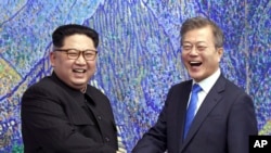 Tổng thống Hàn Quốc Moon Jae-in (phải) bắt tay với lãnh tụ Triều Tiên Kim Jong Un trong cuộc gặp tại làng Bàng Môn Điếm vào ngày 27/4/2018.