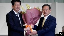 Ông Yoshihide Suga (phải) và người tiền nhiệm Shinzo Abe. 