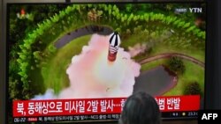 A man watches a television screen showing a news broadcast with file footage of a North Korean missile test, at a railway station in Seoul on July 19, 2023.