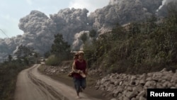 Dân làng bỏ chạy trong lúc núi lửa Sinabung phun trào tại làng Sigarang-Garang trong huyện Karo, tỉnh Bắc Sumatra ở Indonesia.