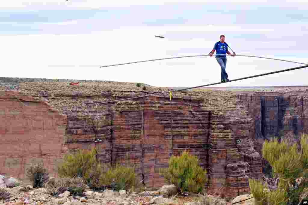 Tay mạo hiểm Nik Wallenda gần hoàn tất nỗ lực đi trên dây căng qua hẻm núi sông Little Colorado ở đông bắc bang Arizona, ngày 23 tháng 6, 2013. Anh phải vượt qua hẻm núi trên sợi dây cáp bằng thép chỉ rộng 5cm.