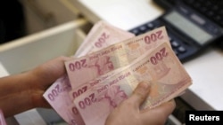 FILE PHOTO: A money changer counts Turkish lira bills at an currency exchange office in central Istanbul, Turkey