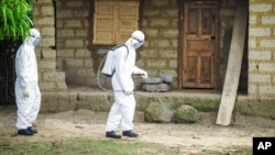 Nhân viên y tế xịt thuốc khử trùng bên ngoài căn nhà của một người bị nghi nhiễm Ebola ờ vùng ngoại ô Freetown, Sierra Leone., ngày 21 tháng 10, 2014.