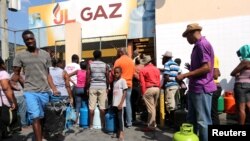 Moun ki t ap tann pou yo achte gaz nan yon makèt nan Pòtoprens, Ayiti, an jounen samdi 16 fevriye 2019 la. 