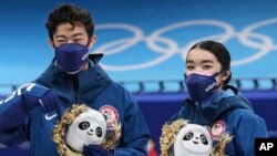 Patine atistik Ameriken Karen Chen ak Nathan Chen, ki ranpote meday ajan, poze pou yo foto apre konpetisyon ekip la nan Jezolenpik Ive Peken yo, 7 Fevriye 2022. 