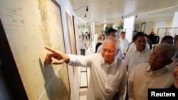 Ngoại trưởng Philippines Albert Del Rosario chỉ vào bản đồ cổ về Biển Đông được trưng bày tại trường đại học Công giáo ở Manila, ngày 11/9/2014.