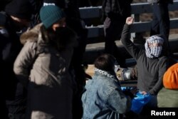 Gösterilerde bazı göstericiler yüzlerini maskelerle kapatıyor.