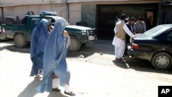 Những phụ nữ Afghanistan đi qua nhà khách Park Palace ngày 15/5/2015 ở Kabul sau khi nhà khách này bị tấn công bởi các tay súng.