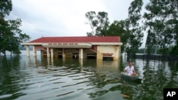 Một người đàn ông chèo xuồng qua thôn Nam Hài bị ngập ở huyện Chương Mỹ, Hà Nội, ngày 31 tháng 7, 2018.