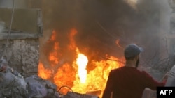 People and rescuers try to put out a fire at the site of an Israeli airstrike that targeted a densely populated neighborhood in Lebanon's eastern city of Baalbek on November 6, 2024.