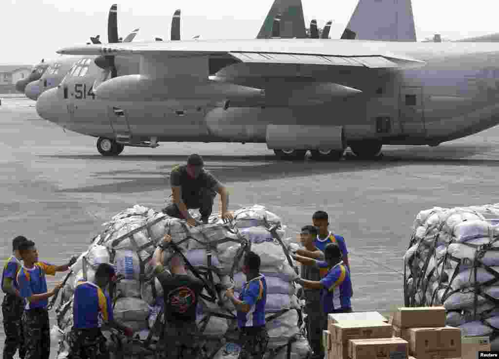 Nhân viên quân đội Mỹ và Philippines đưa hàng cứu trợ lên máy bay vận tải C-130 để chở tới miền trung Philippines từ căn cứ không quân Villamor tại Manila, ngày 11/11/2013.