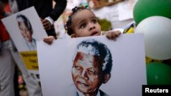 Bé trai 2 tuổi cầm hình cựu Tổng thống Nam Phi Nelson Mandela.