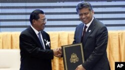 Thủ tướng Campuchia Hun Sen và Tổng Thư ký ASEAN Surin Pitsuwan bắt tay sau buổi lễ thông qua Tuyên bố ASEAN về Nhân quyền tại Phnom Penh, ngày 18/11/2012.