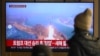 People watch a television screen showing a news broadcast with file footage of a North Korean missile test, at a train station in Seoul on January 14, 2025.