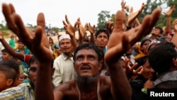 Người tị nạn Rohingya giơ tay nhận đồ cứu trợ ở Bangladesh hôm 9/9.