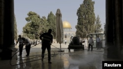 Người Palestine dọn dẹp Đền thờ Hồi giáo Al Aqsa sau vụ đụng độ với cảnh sát Israel ngày 15/9/2015. 