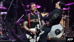 Jesse Hughes (trái), ca sĩ của ban nhạc Eagles of Death Metal, biểu diễn trên sân khấu tại phòng hòa nhạc Olympia ở Paris, ngày 16/2/2016. 