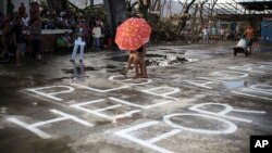 Nạn nhân bão Haiyan kêu gọi giúp đỡ tại thị trấn Burauen, tỉnh Leyte, miền trung Philippines, ngày 15/11/2013. 