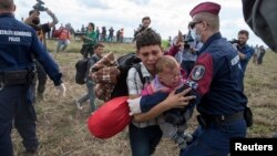 Cảnh sát Hungary ngăn chặn di dân trên một cánh đồng gần làng Röszke, Hungary, ngày 8/9/2015.