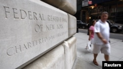 People walk past the Federal Reserve building where talks were held by officials regarding the situation with investment bank Lehman Brothers in New York, September 14, 2008. Talks faltered when Britain's Barclays Plc, which had appeared to be front-runne